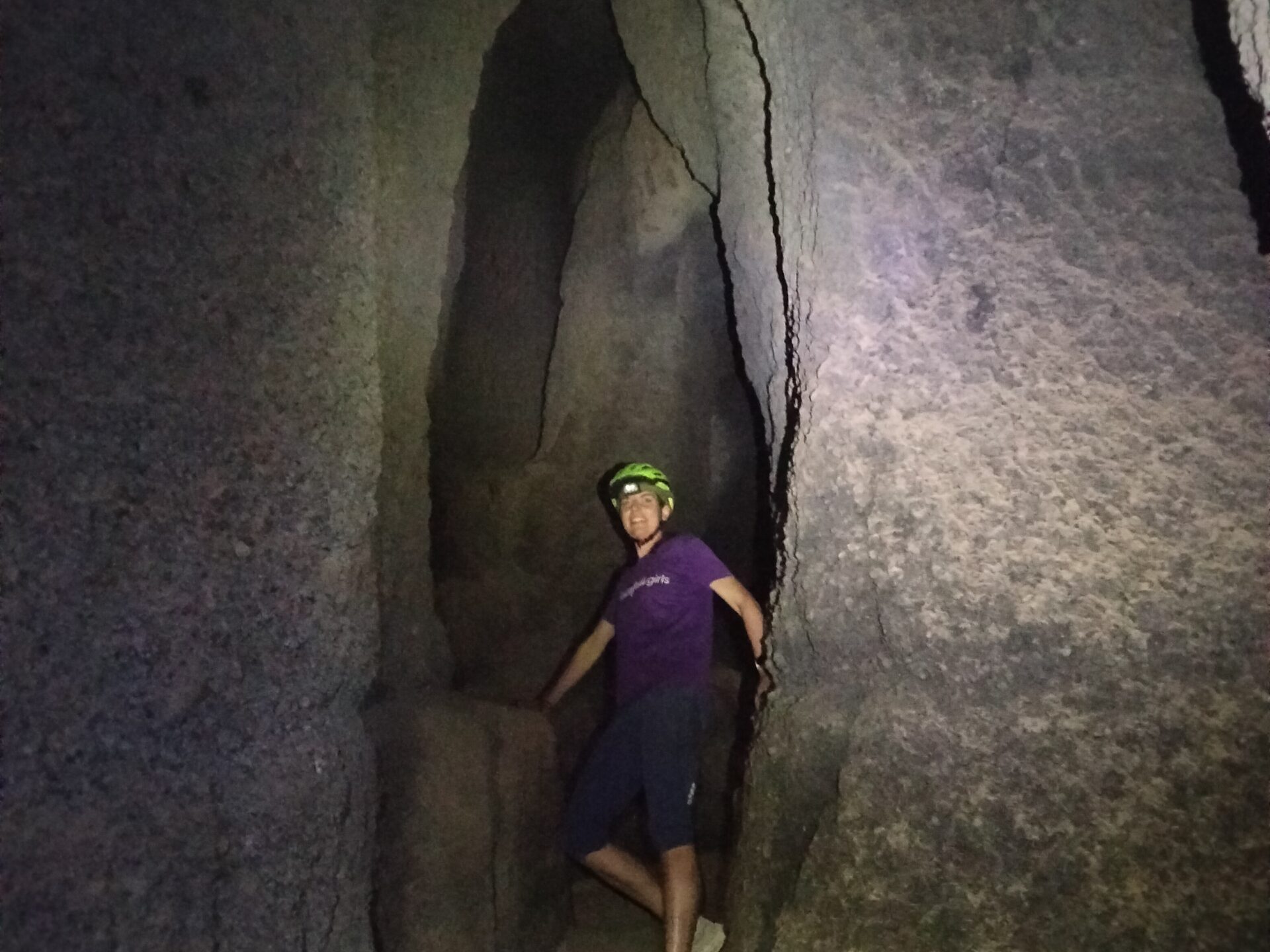 a man standing next to a stone wall