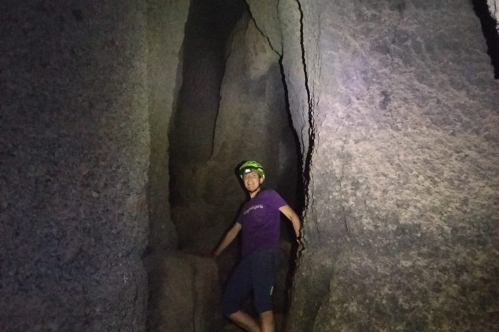a man standing next to a stone wall