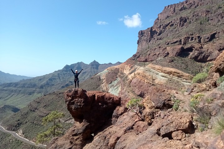 a person standing on a rock on top of a rck mountain
