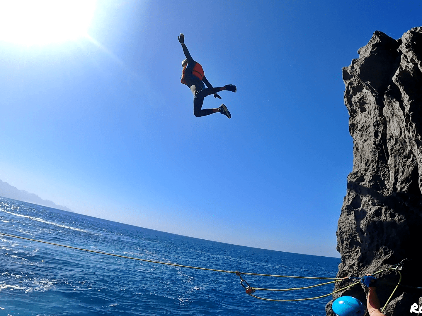 a man flying through the air while swimming in a body of water