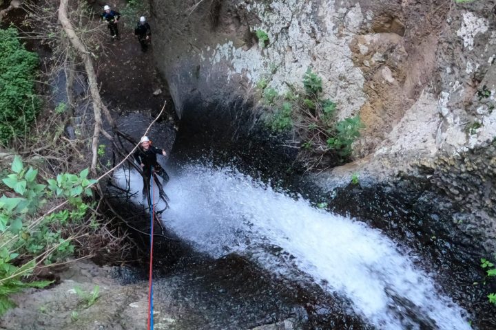 a man standing next to a waterfall