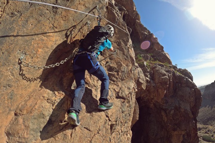 a man flying through the air on a rocky hill