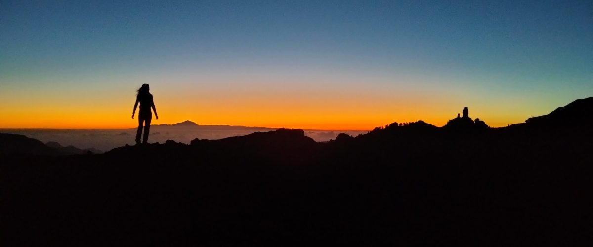 Roque Nublo sunset view astronomy hike a man standing in front of a sunset