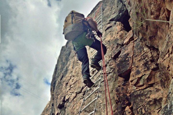 a man flying through the air on a rock