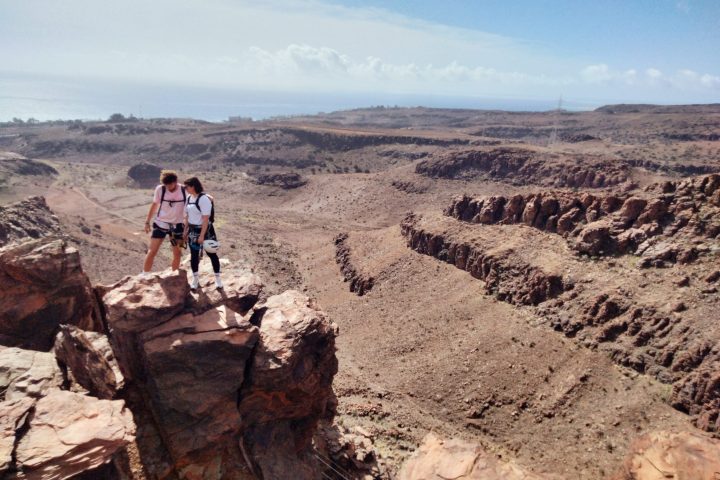 a man that is standing in the dirt with a mountain in the desert