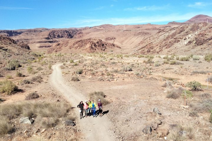 a group of people walking down a dirt road