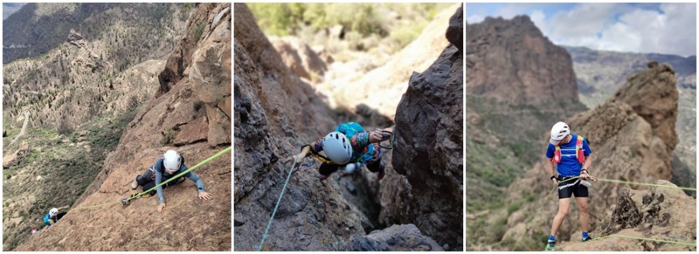 Three climbers scaling rocky cliffs wearing helmets and harnesses, set against a mountainous landscape.